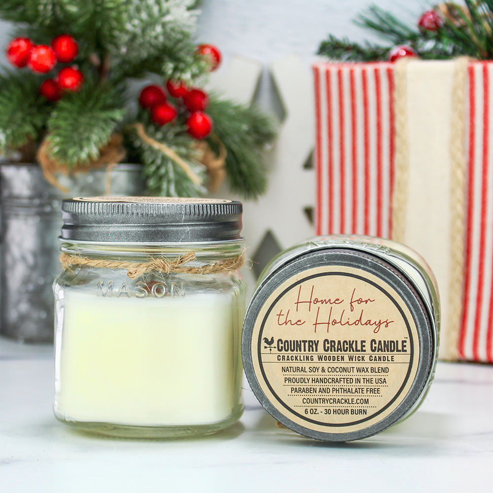 Jar candle with decorative label on a surface with Christmas decorations in the background