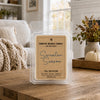 A clear plastic clamshell package of Country Crackle Candle 'Sweater Season' fall collection wax melts sits on a rustic wooden table in a cozy, softly-lit living room setting.